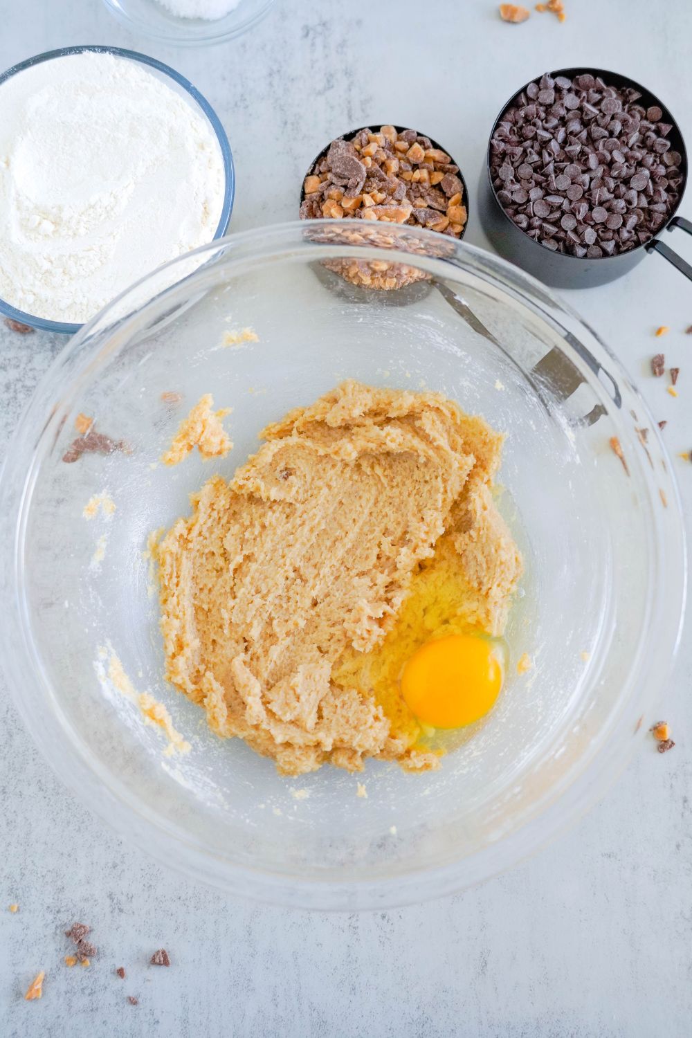 creamed butter and sugar mixed together with an egg on top in a glass bowl 
