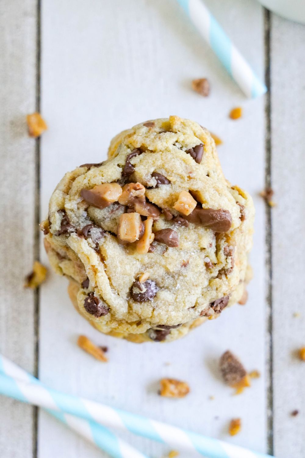 Chocolate Chip Toffee Cookies stacked on top of each other with one cookie with it bit in half 