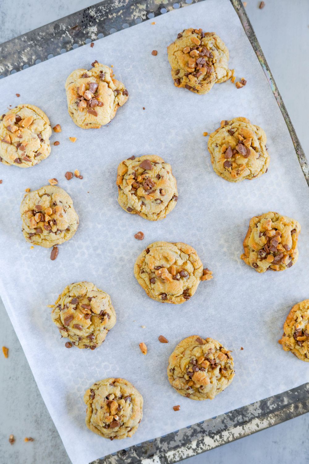 baked Chocolate Chip Toffee Cookies on a baking sheet on table 