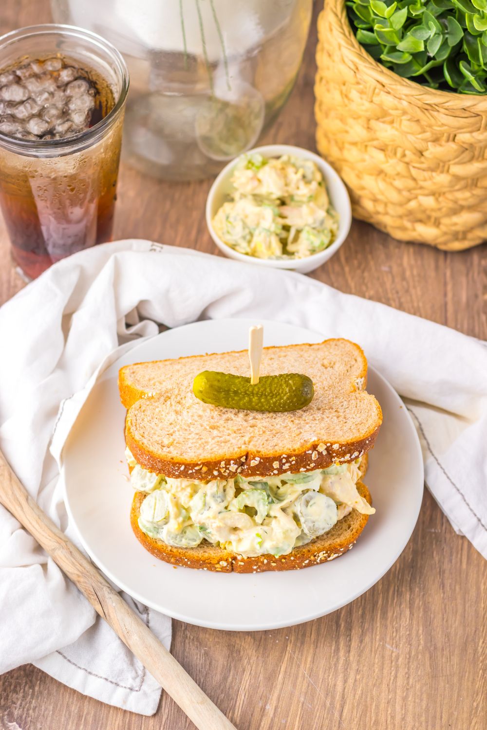Pickle Chicken Salad on a plate with a drink and more salad in a bowl to the side 