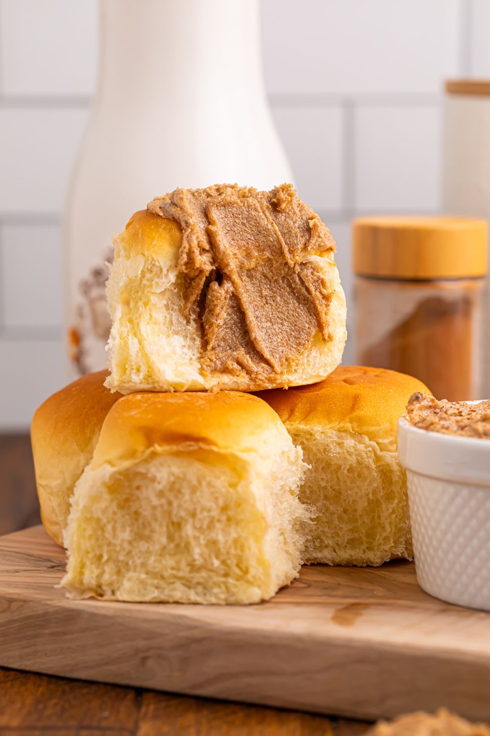 Brown Sugar Cinnamon Butter spread on rolls sitting on a cutting board on table 