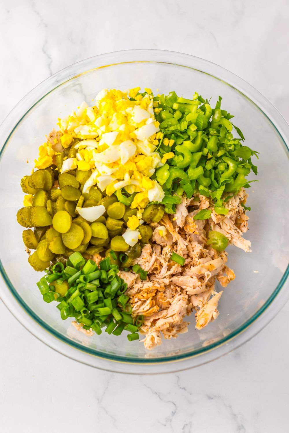 all the ingredients for the Pickle Chicken Salad in a glass bowl on table