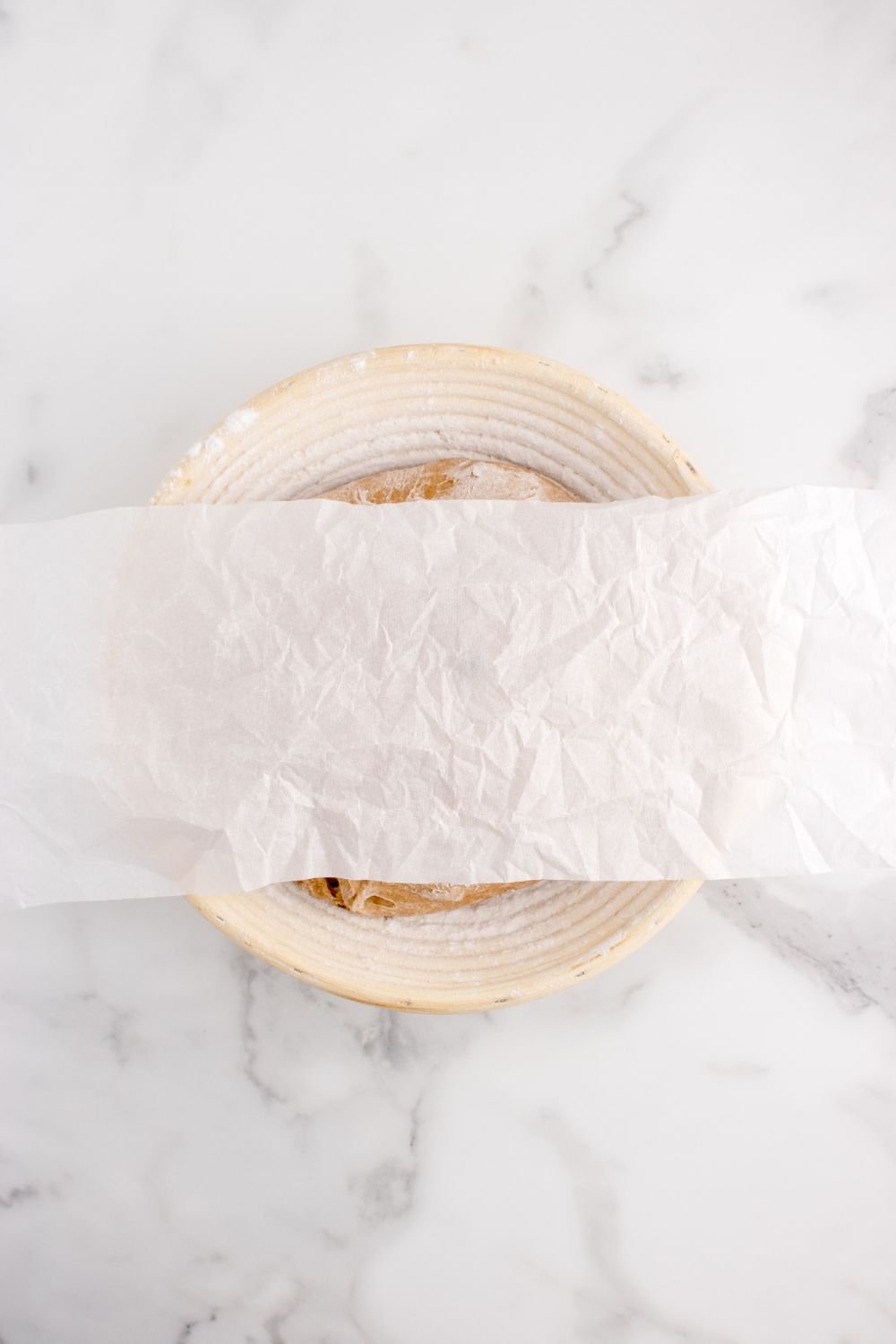 cinnamon raisin bread dough in a bowl covered with wax paper 