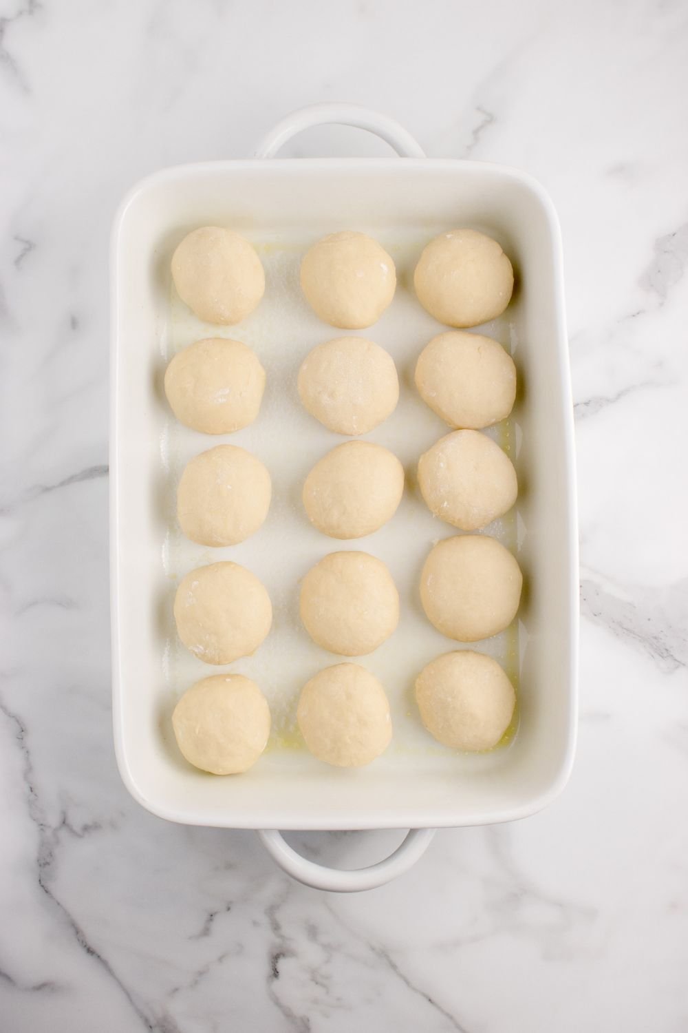 Hawaiian rolls dough in a baking dish on counter in a baking dish 