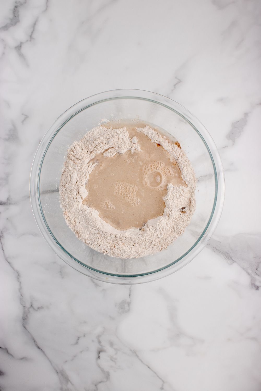 flour and yeast mixture in a glass bowl for the cinnamon raisin bread 