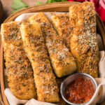 Copycat Pizza Hut Breadsticks in a serving basket with a side of marinara