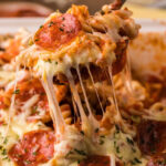 TikTok Pizza Pasta Casserole bite being lifted up with a serving fork
