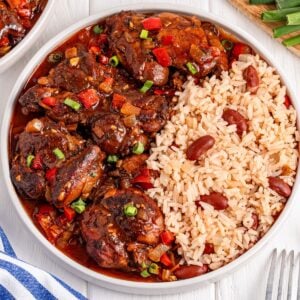 Jamaican Brown Stew Chicken and rice and beans on a plate on table