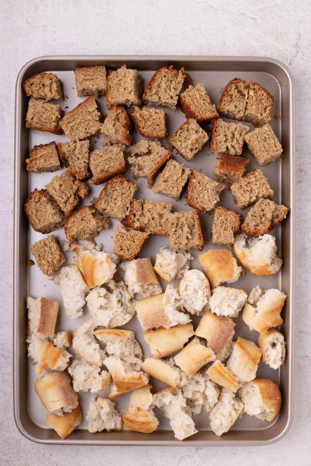 sheet pan with diced bread and banana bread cubed for making Banana Bread Pudding