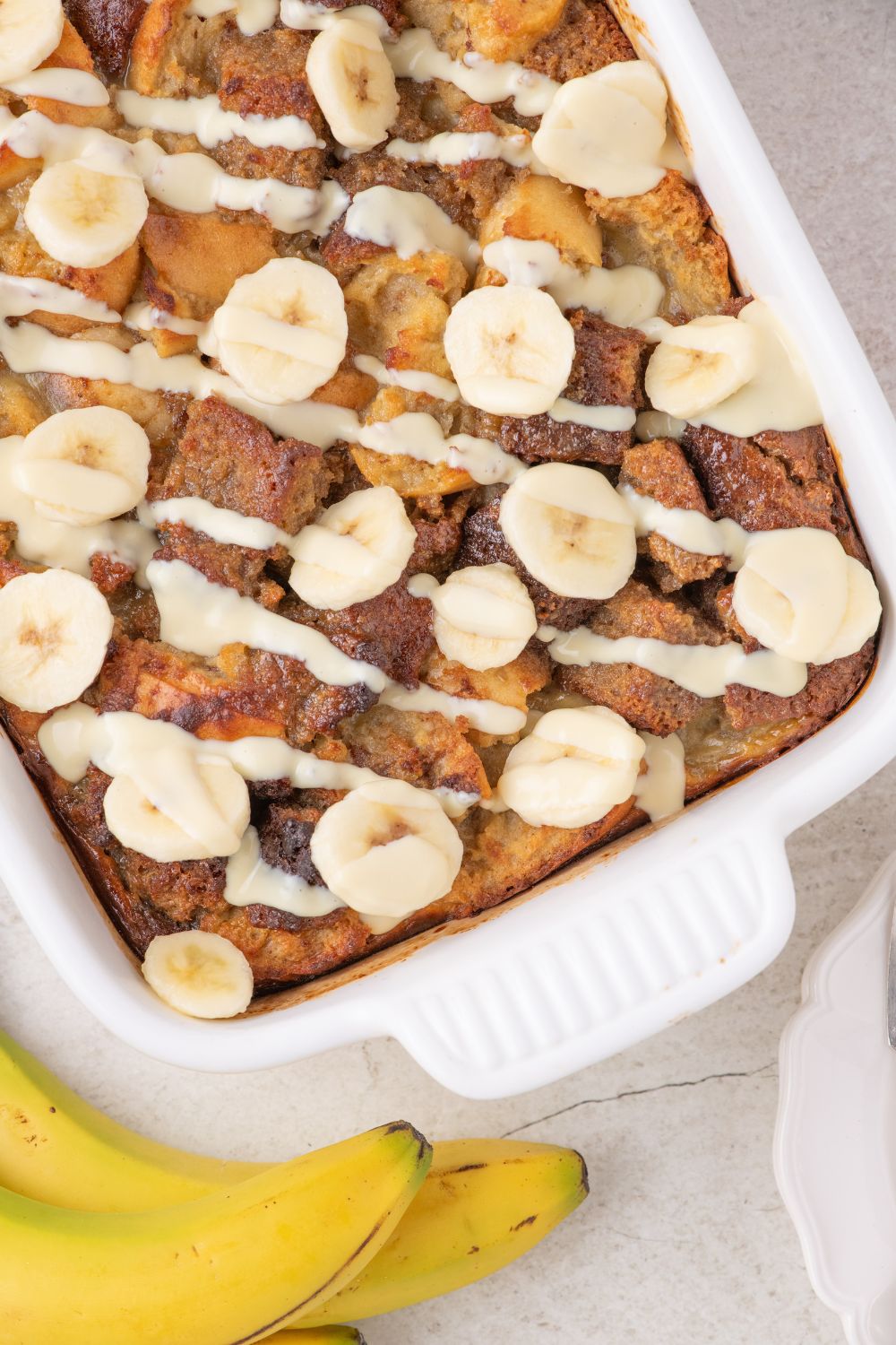 overhead look of Banana Bread Pudding in a casserole dish on table 