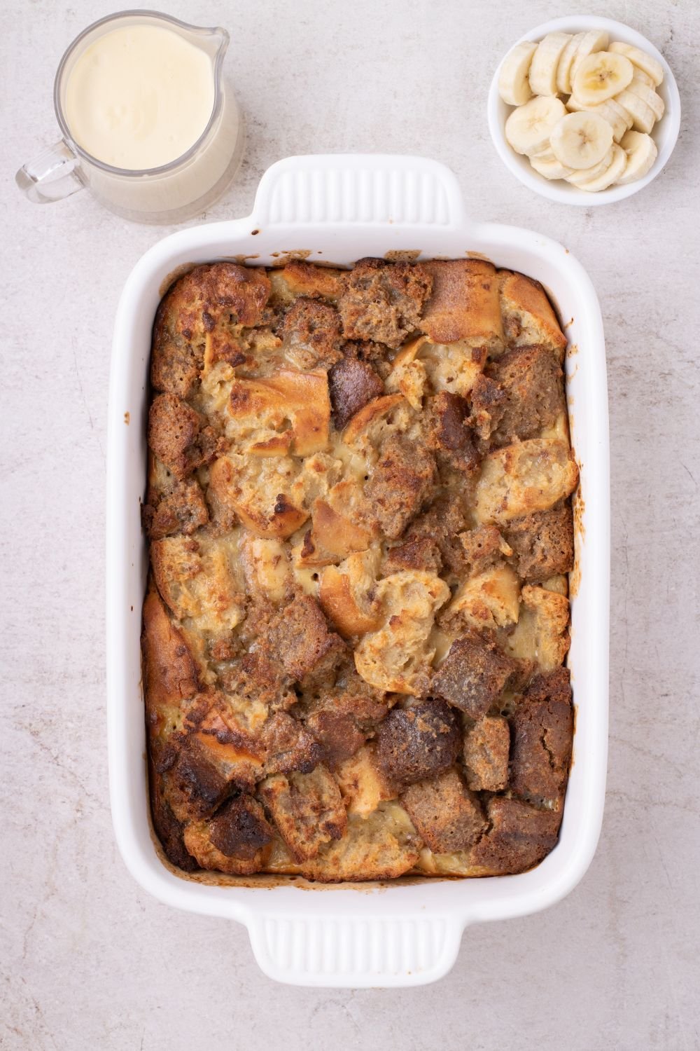 baked Banana Bread Pudding in a casserole dish on table 