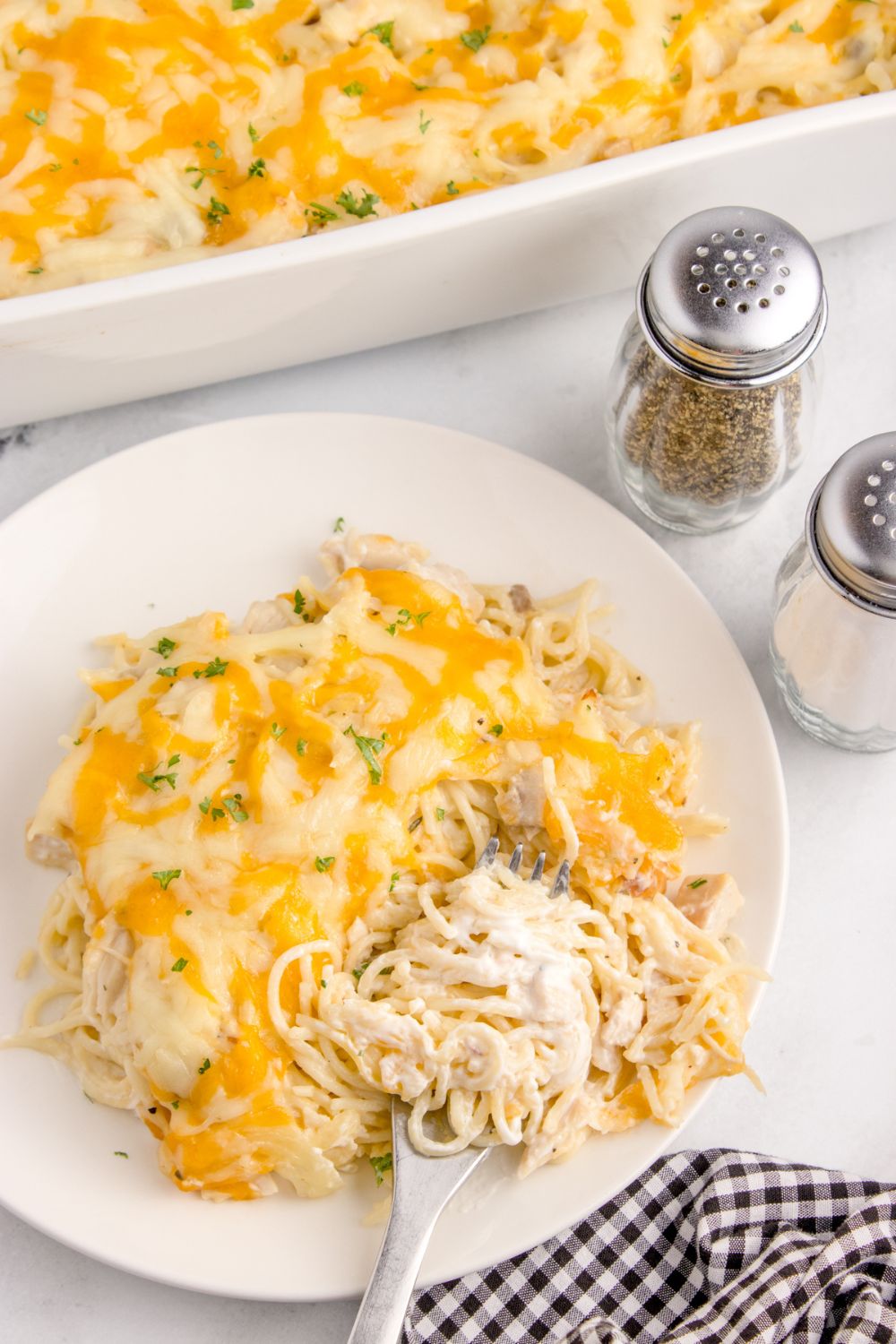 Chicken tetrazzini on a plate with salt and pepper shakers to the side 