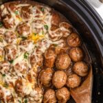 Crock Pot French Onion Meatballs in a slow cooker, with a wooden spoon scooping some up