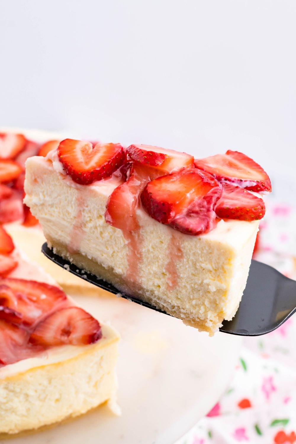 Keto Cheesecake with a slice being lifted off plate with a spatula 