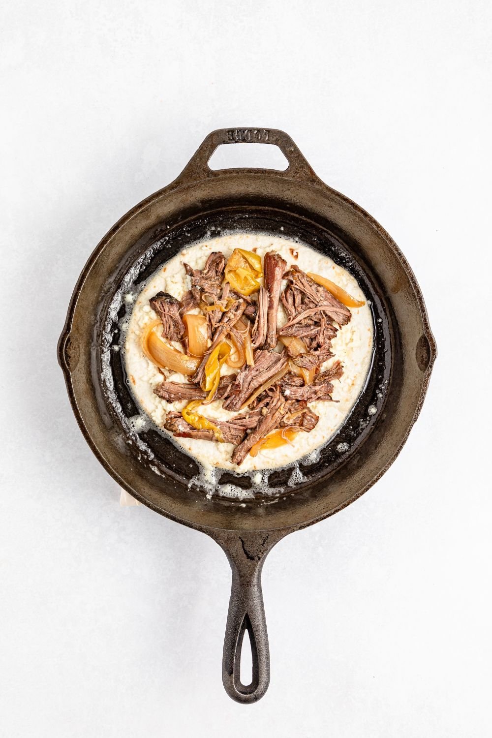 Mississippi Pot Roast Quesadilla being assembled in pan 