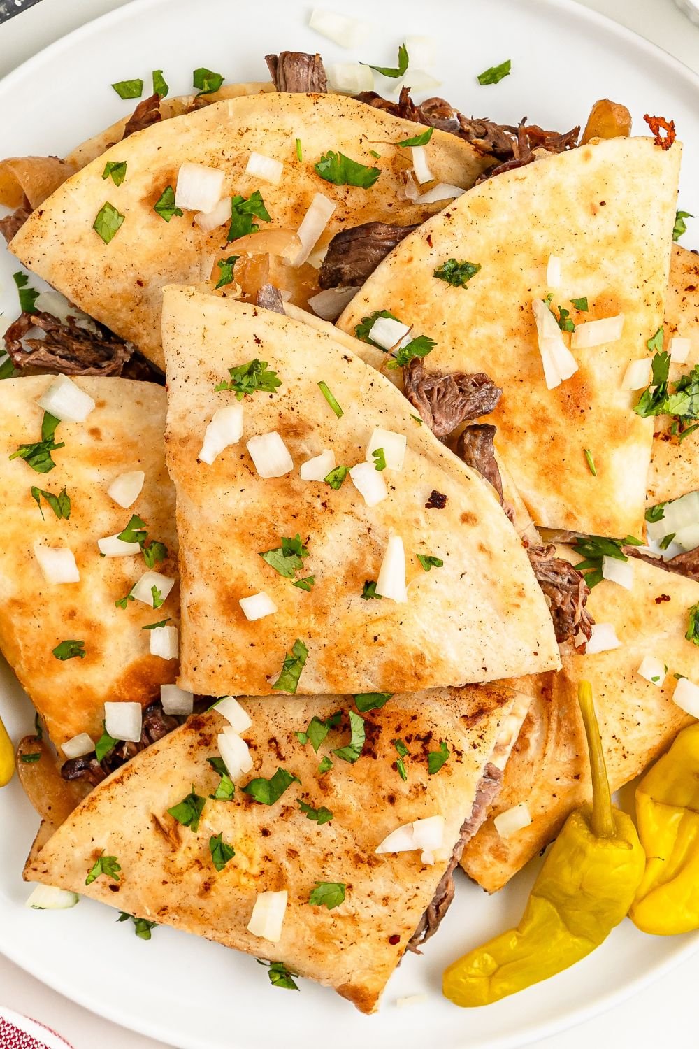Mississippi Pot Roast Quesadillas spread out on table with some peppers 