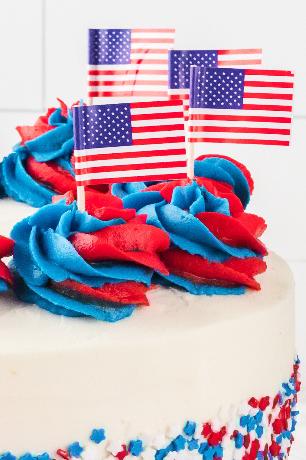 close up of the frosting topped with tiny american flags on top of the whole uncut American Flag Layered Cake 