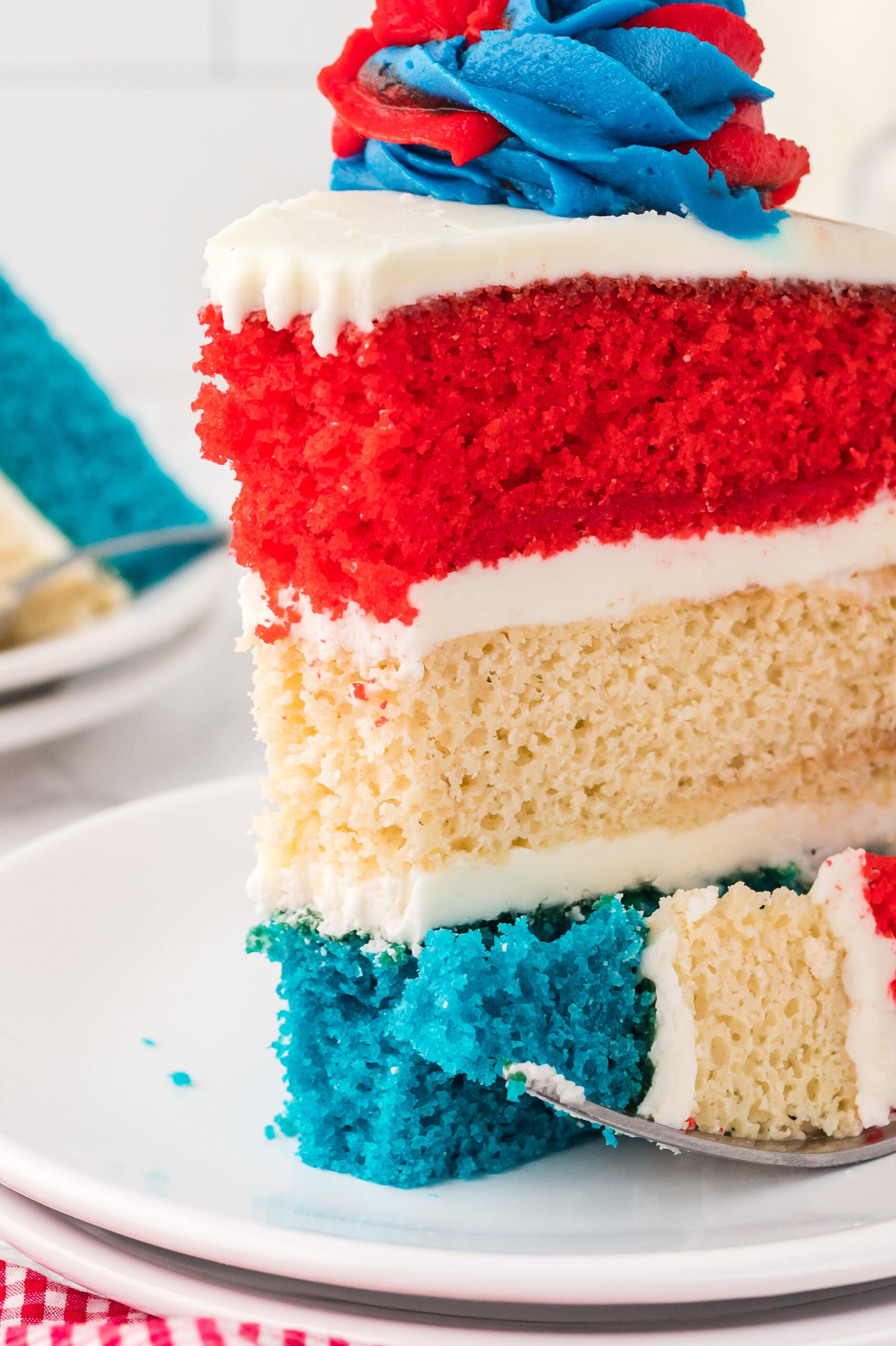 up close shot of a slice of American Flag Layered Cake on a white plate 