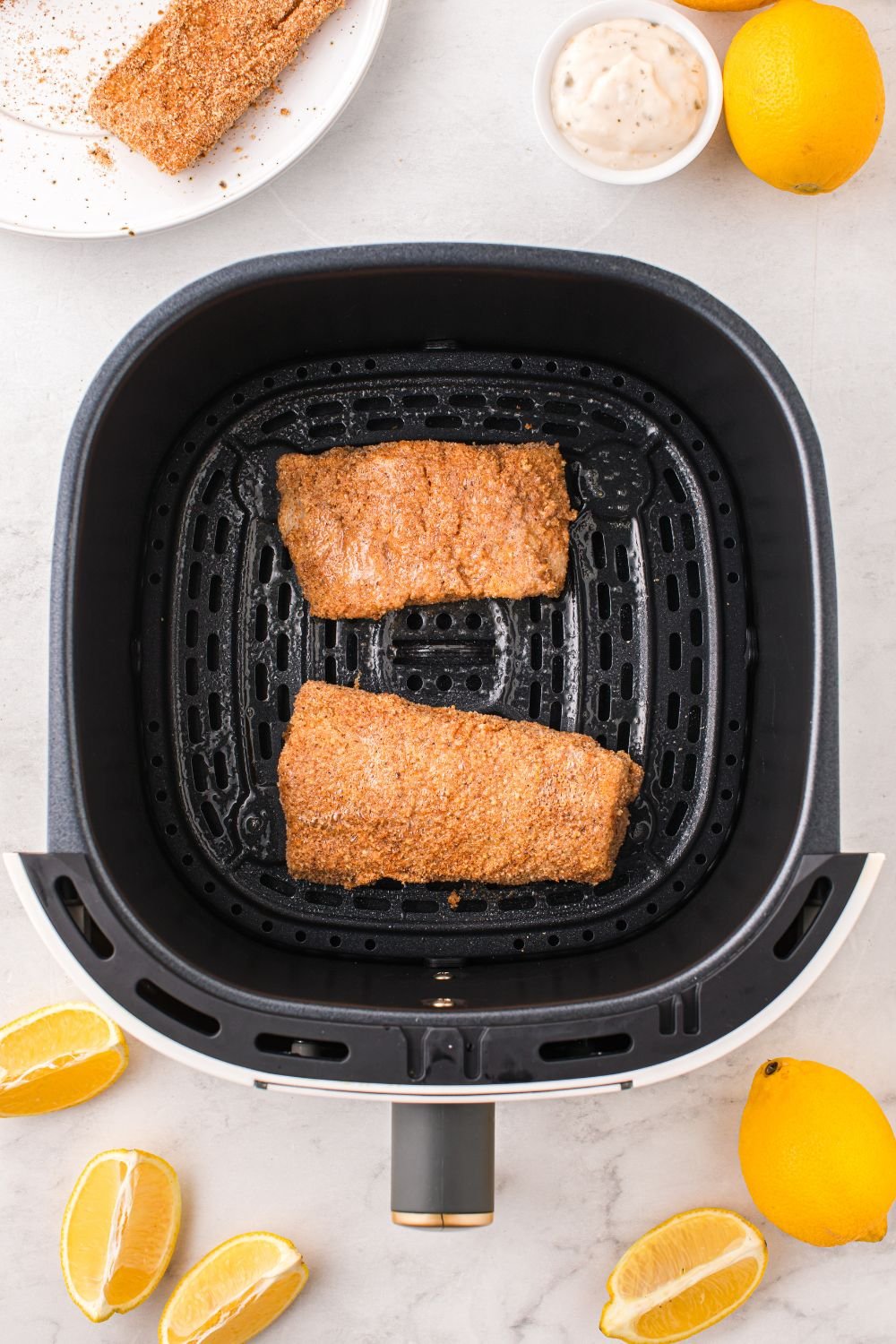 raw breaded fish in air fryer basket