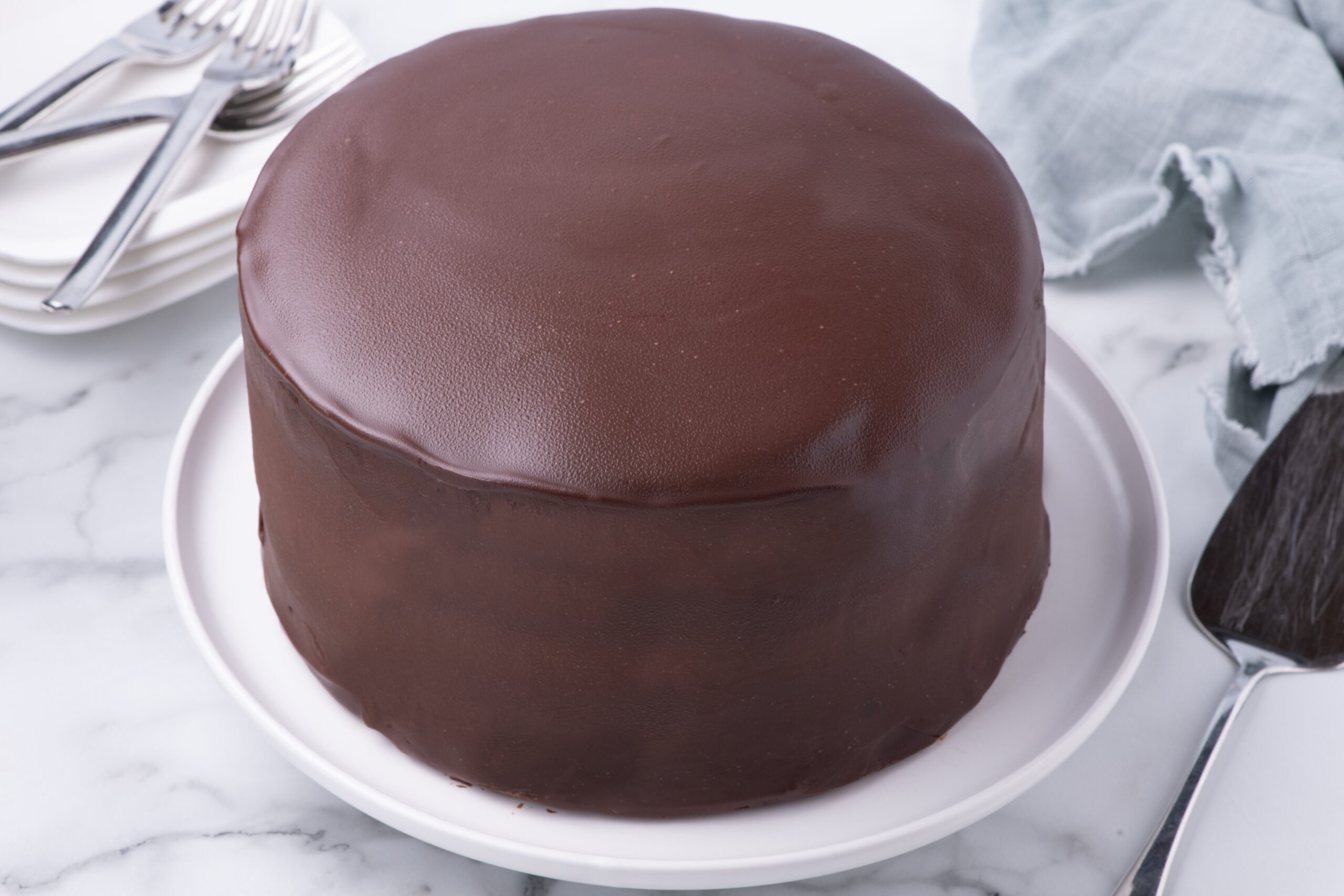 Whole uncut Ding Dong Cake on a white cake stand