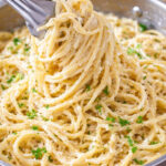 Creamy Garlic Pasta being lifted up in a silver pan
