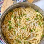 Garlic Parmesan Pasta in a skillet on table with wooden spatula to side