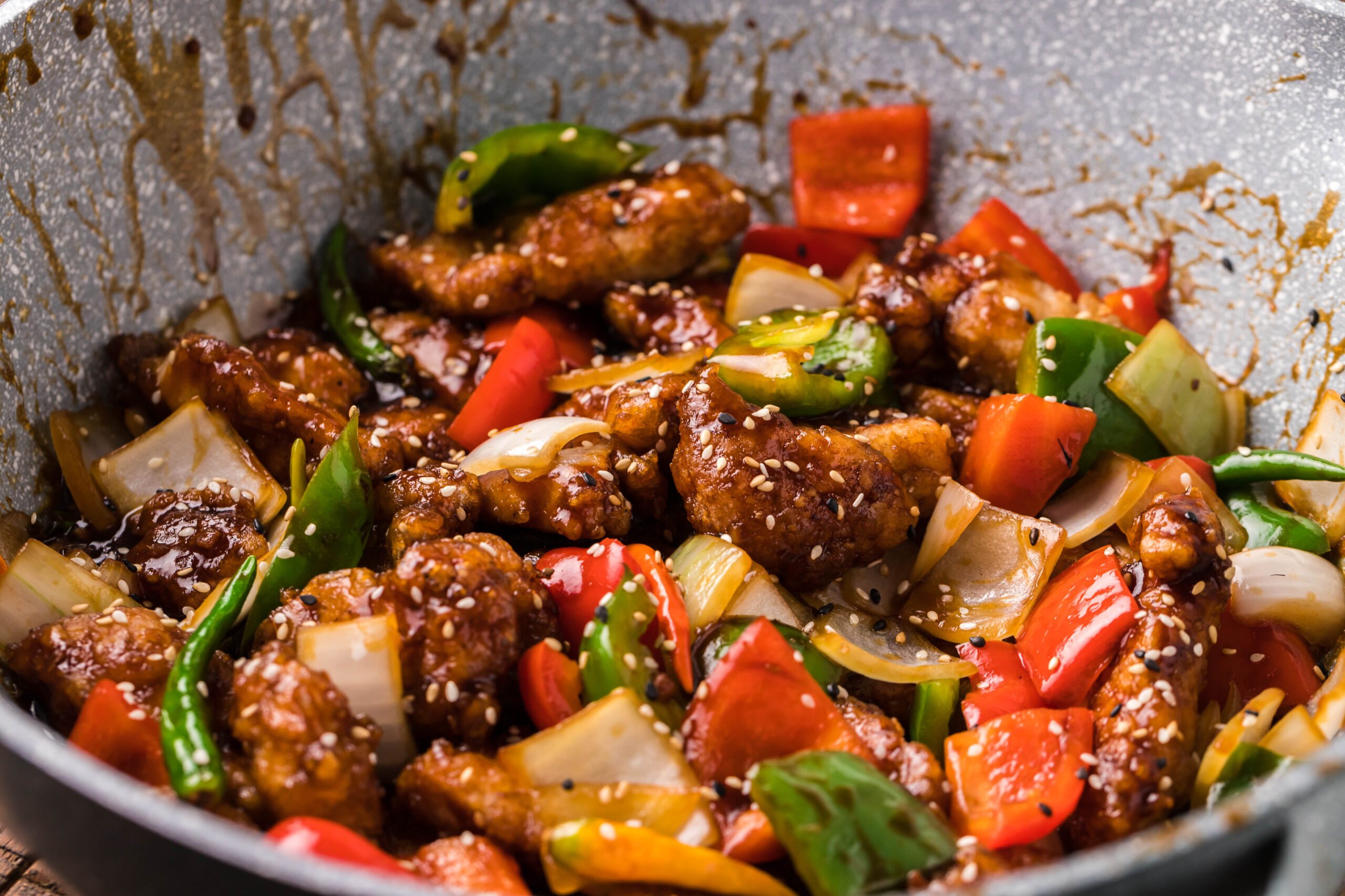 side view of the General Tso Chicken in a skillet covered in sauce