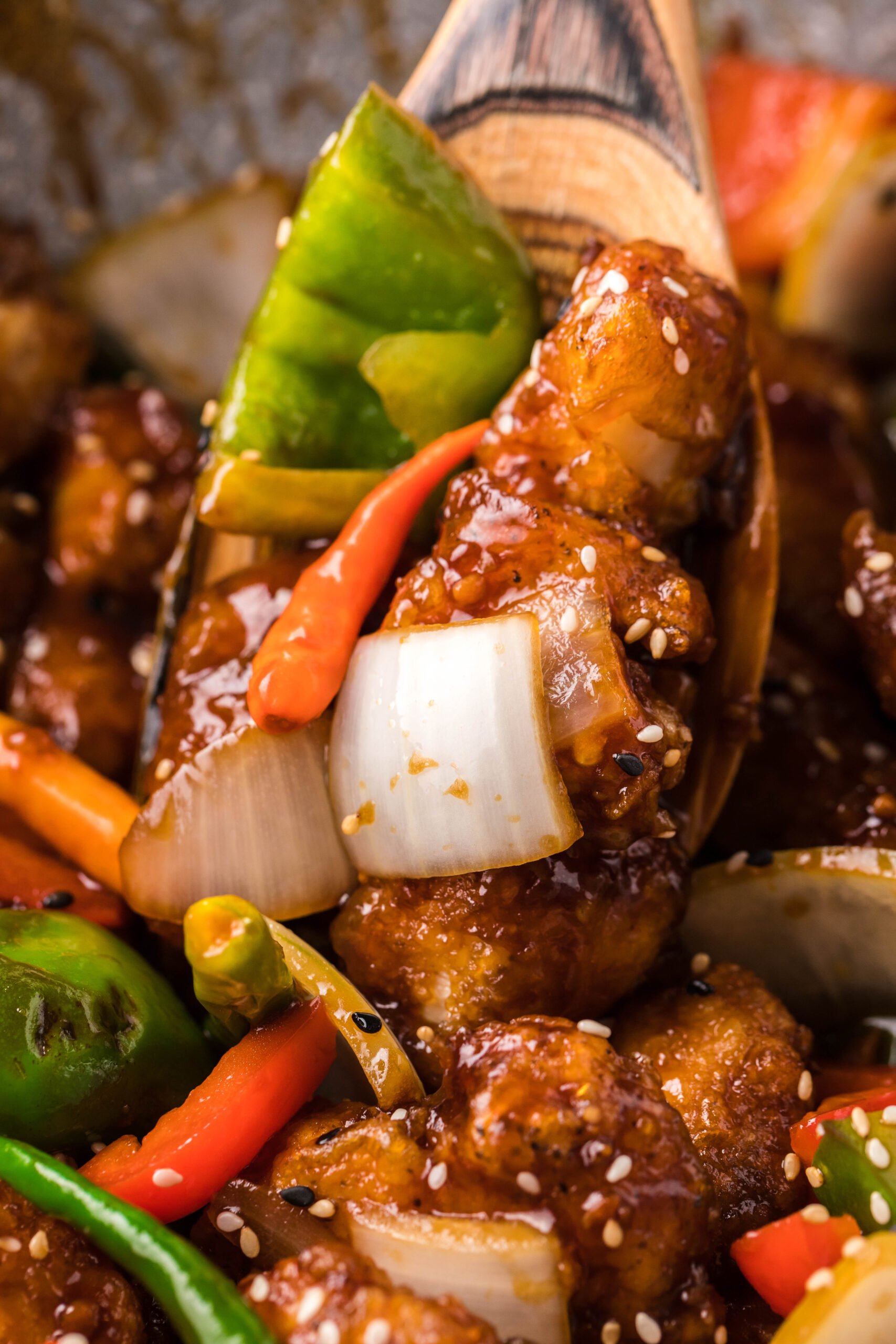 up close shot of the General Tso Chicken on a wooden spoon