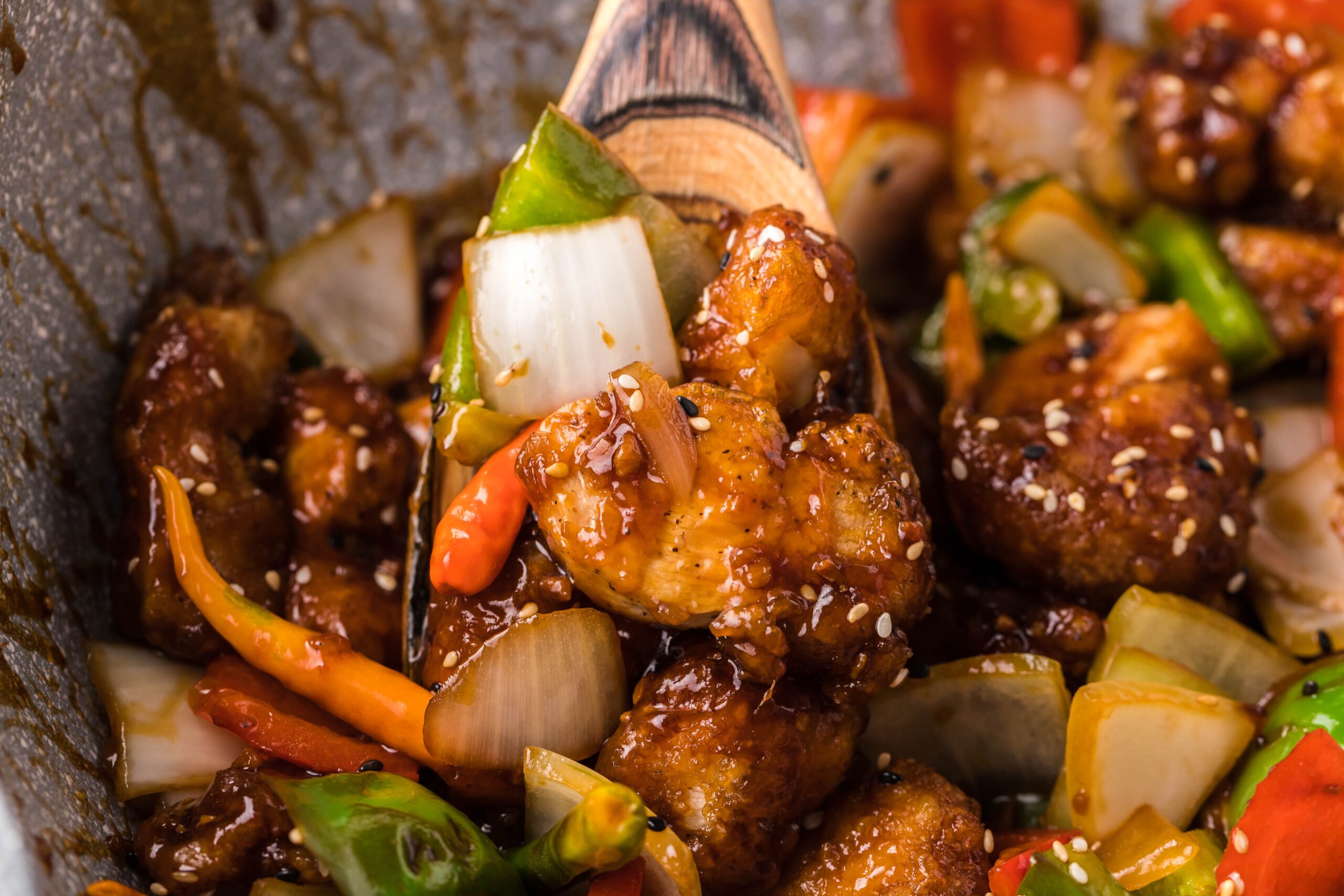 up close shot of the General Tso Chicken being lifted by a spoon