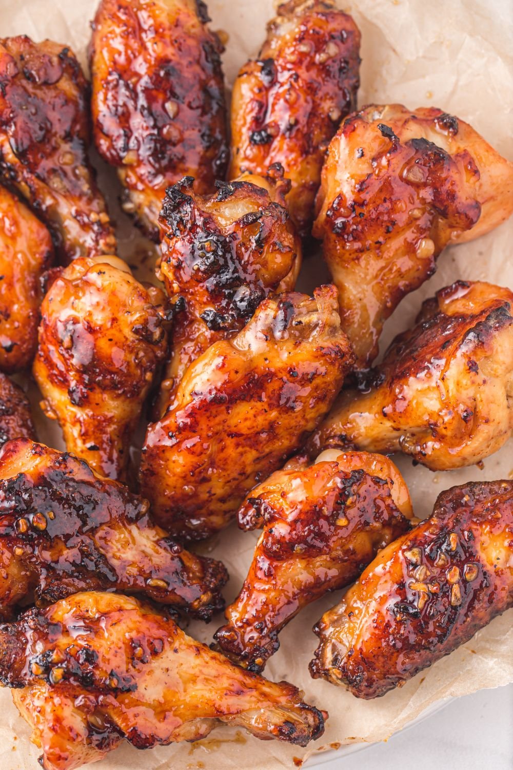 Air Fryer Honey Chicken Wings spread out on a tray showing the sticky glaze./