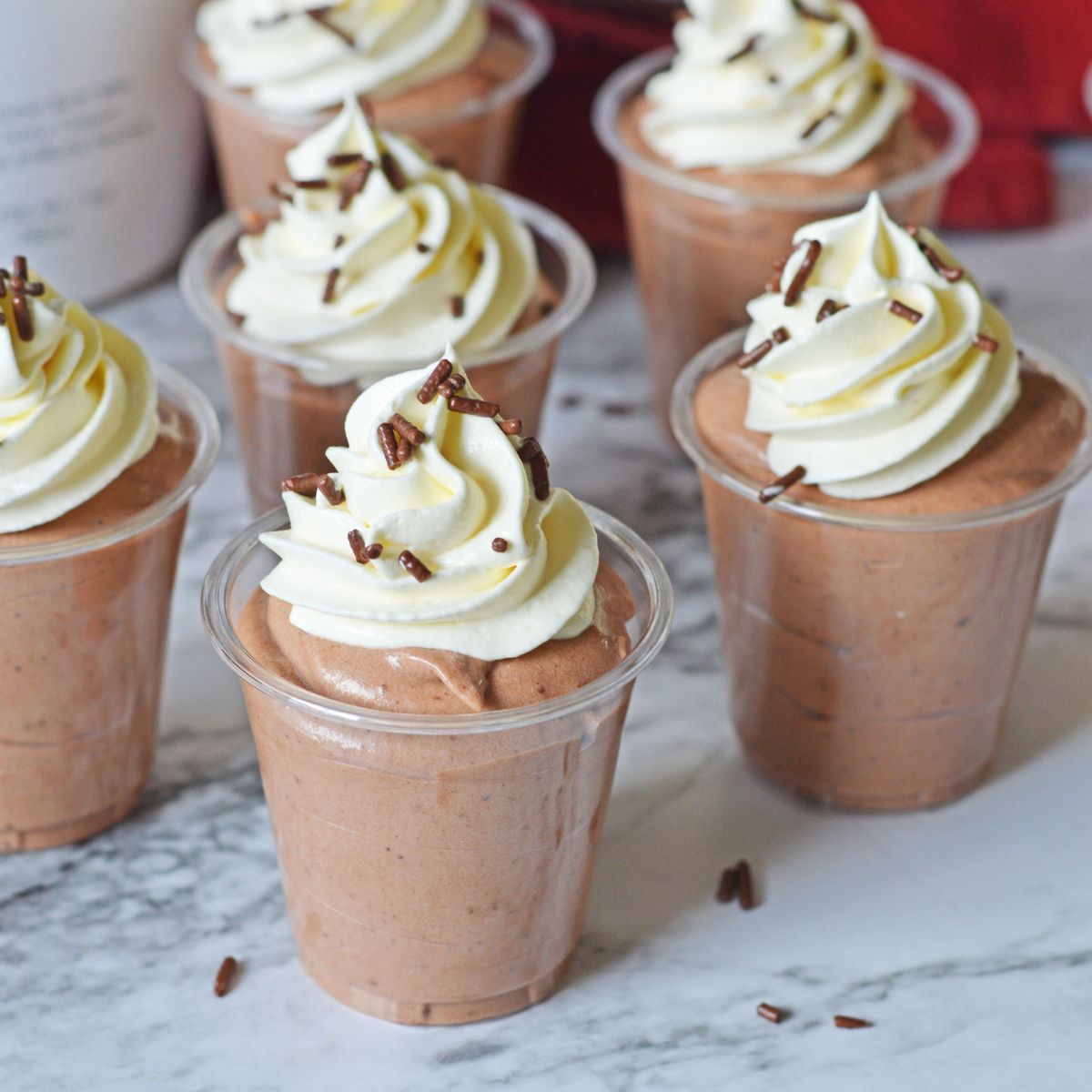 Rumchata Pudding Shots on table with whipped cream on top of each one 