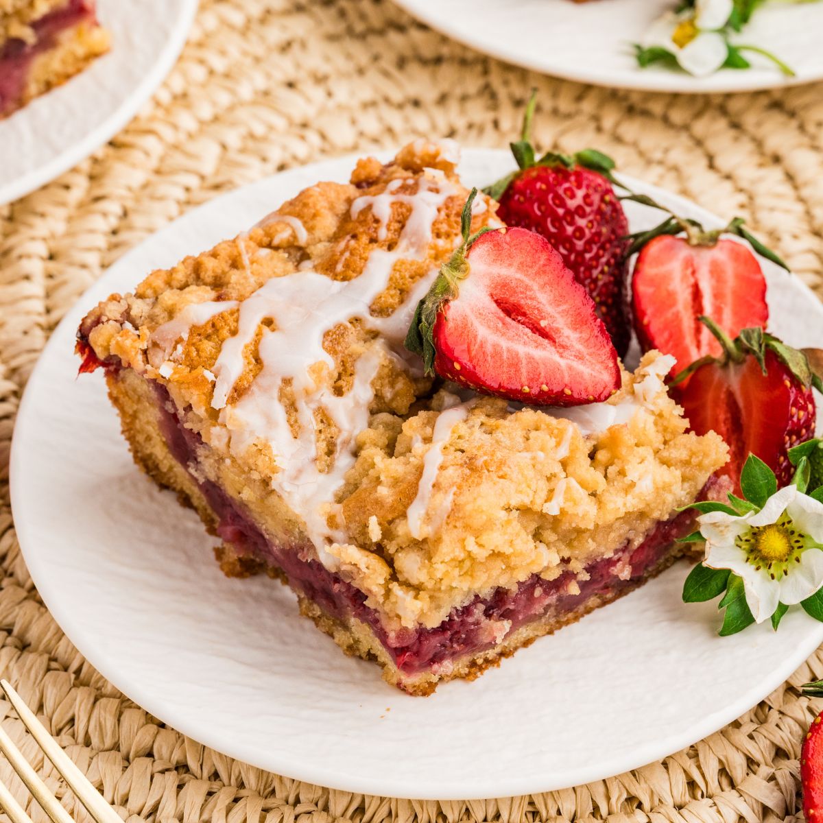 slice of Strawberry Coffee Cake on plate garnished with strawberries and flowers 