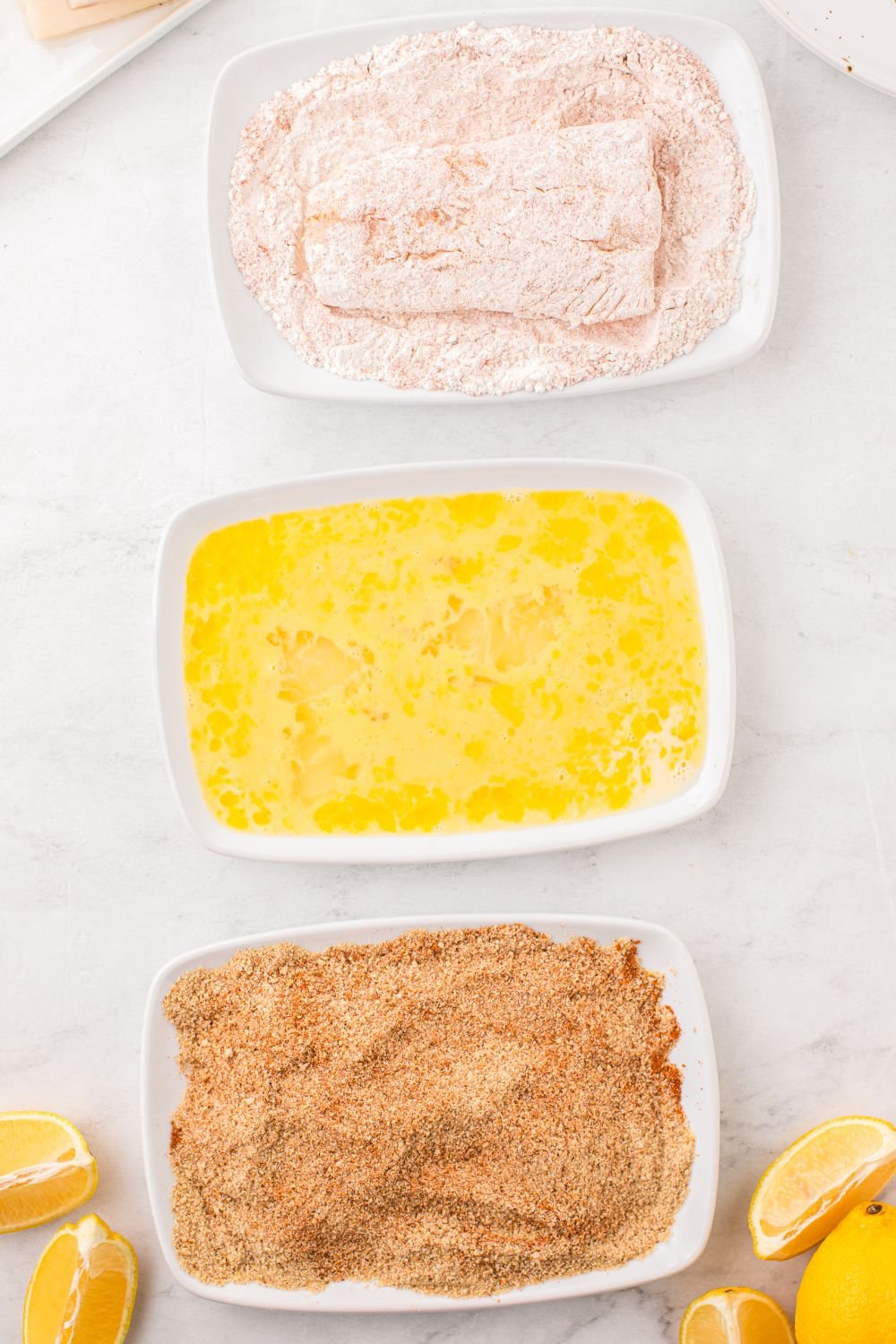 dredging fish in flour in a small bowl 