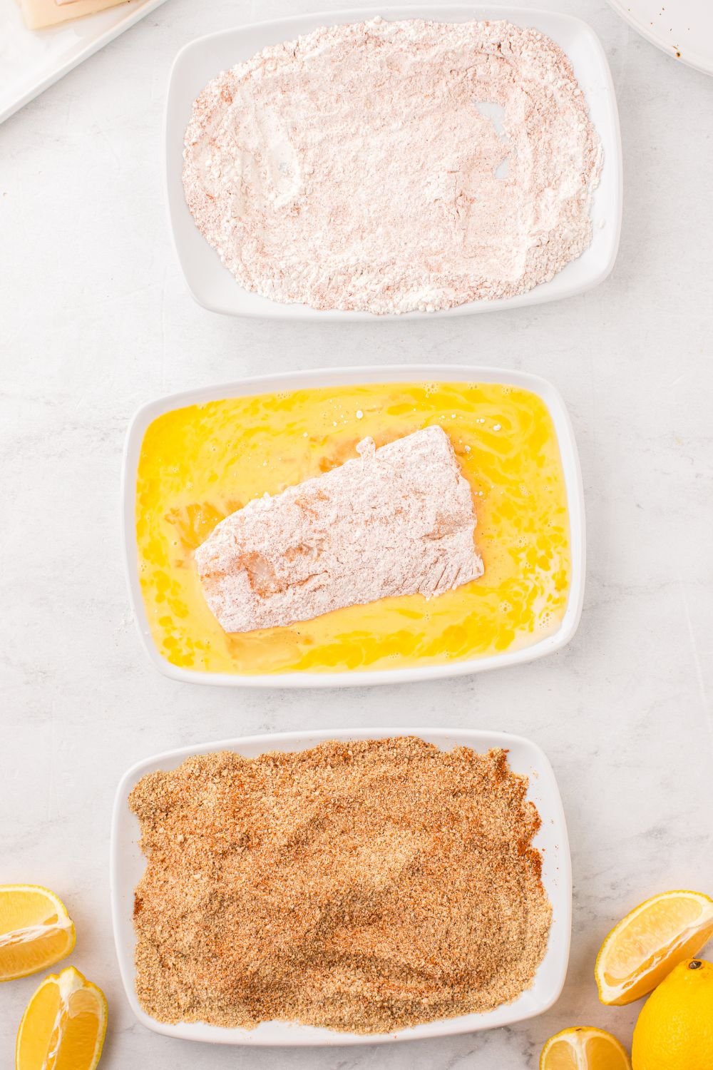 dredging fish fillet in egg wash 