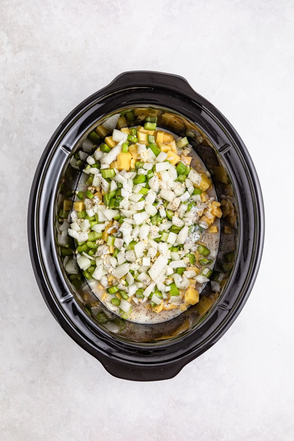raw slow cooker pot pie ingredients in slow cooker on table
