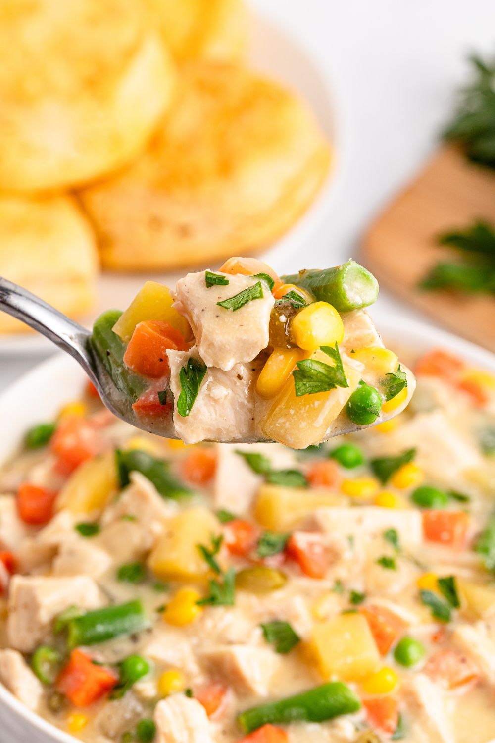 Slow Cooker Chicken Pot Pie in a bowl with a spoon scooping out of it 