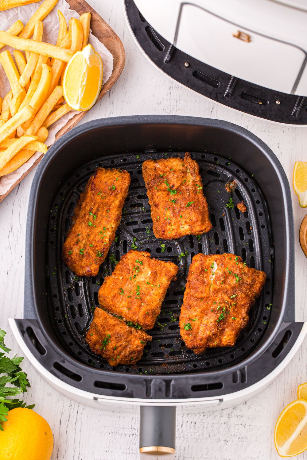 overhead look of air fryer basket with fish inside the air fryer