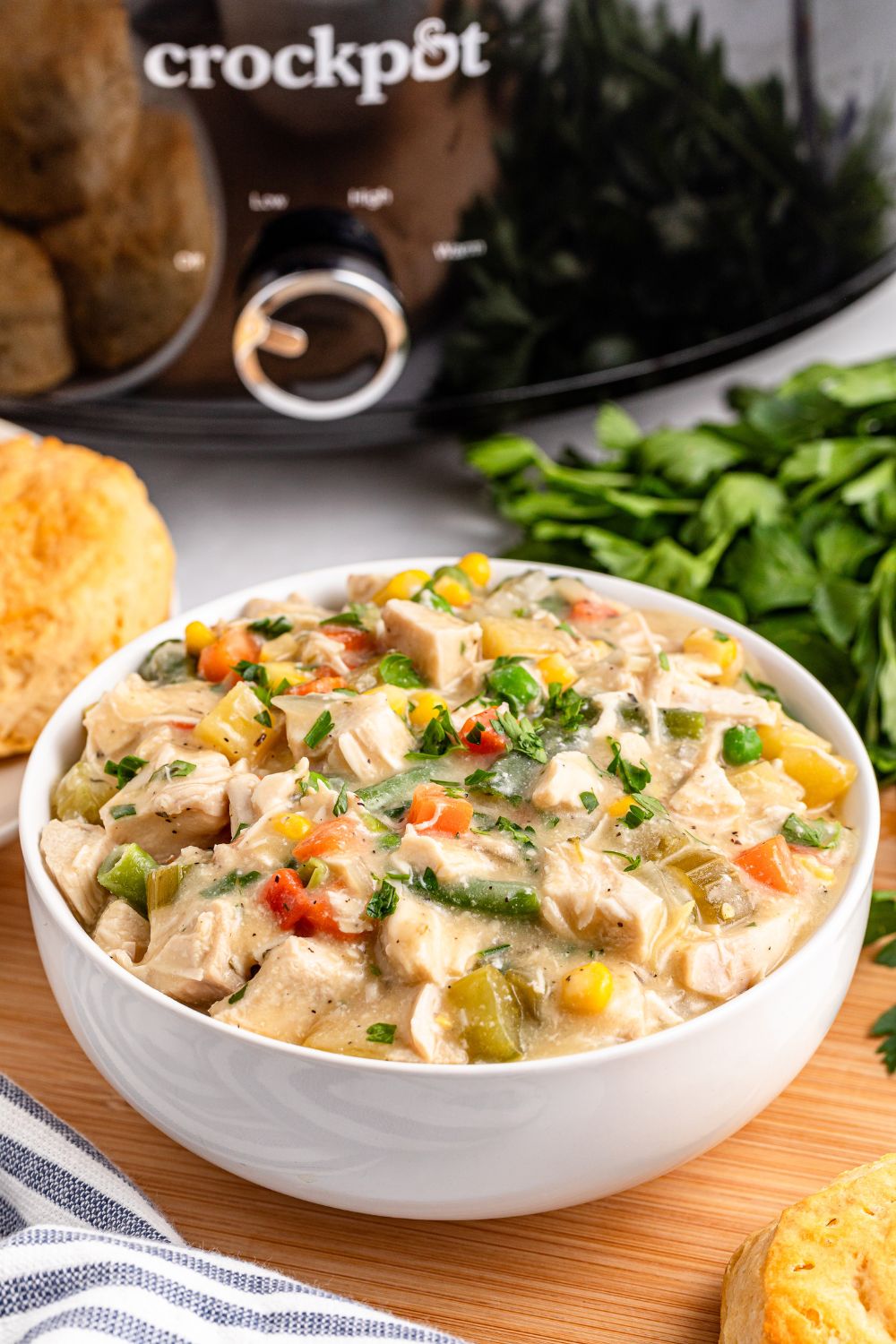 Slow Cooker Chicken Pot Pie in a bowl with a slow cooker behind it on table 