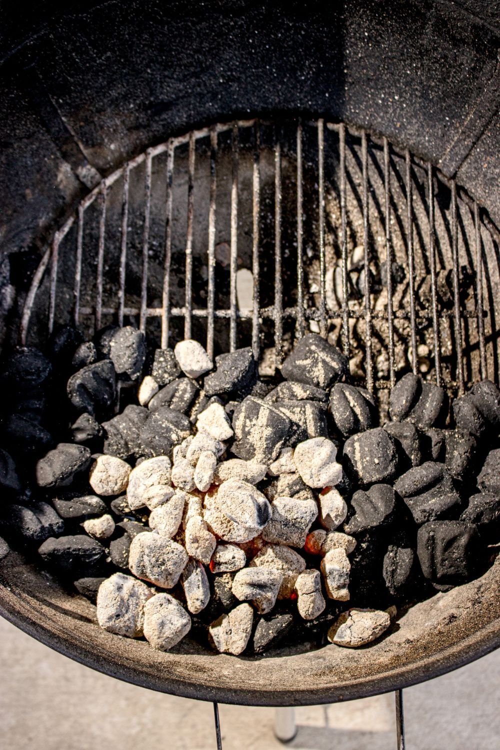 charcoal grill with some coals burned down 