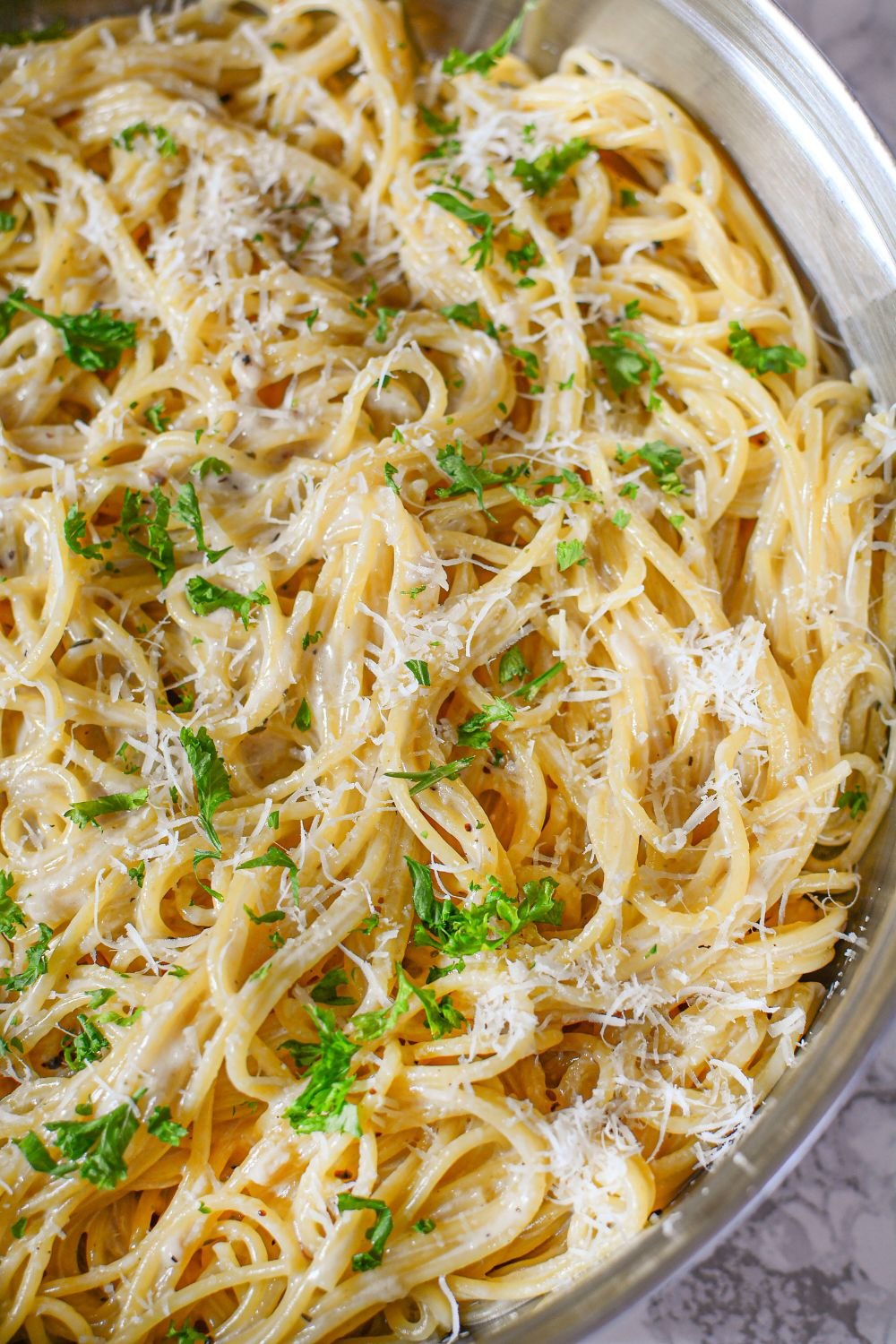 Garlic Parmesan Pasta in a pan topped with parmesan cheese and parsley 