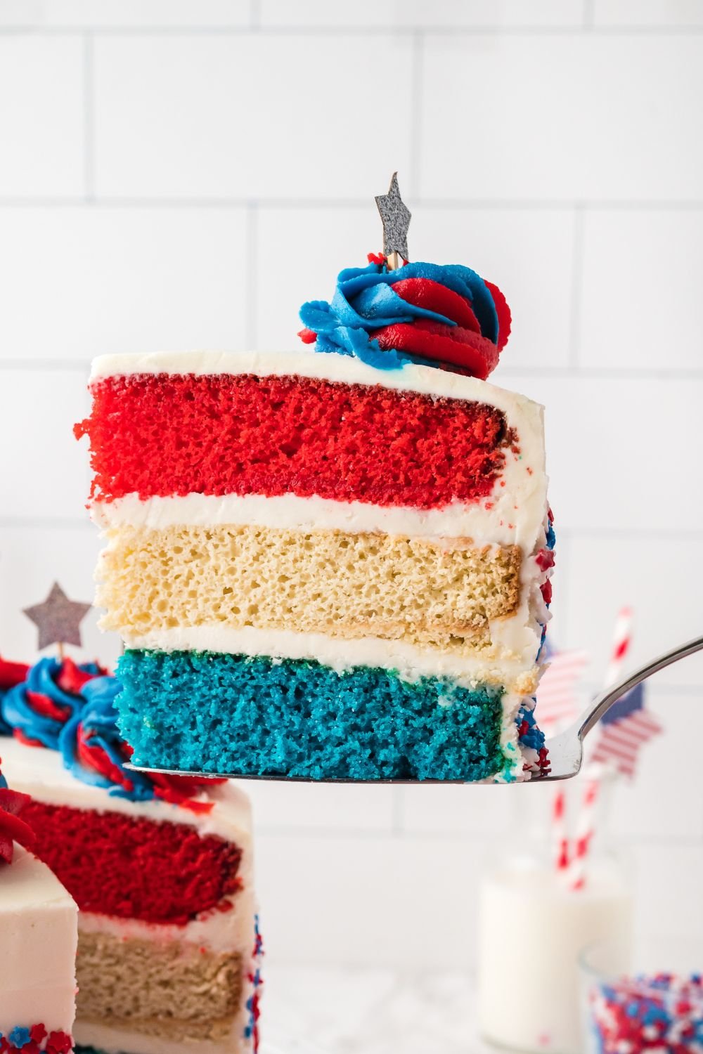 American Flag Cake with a slice taken out of it being lifted out of container