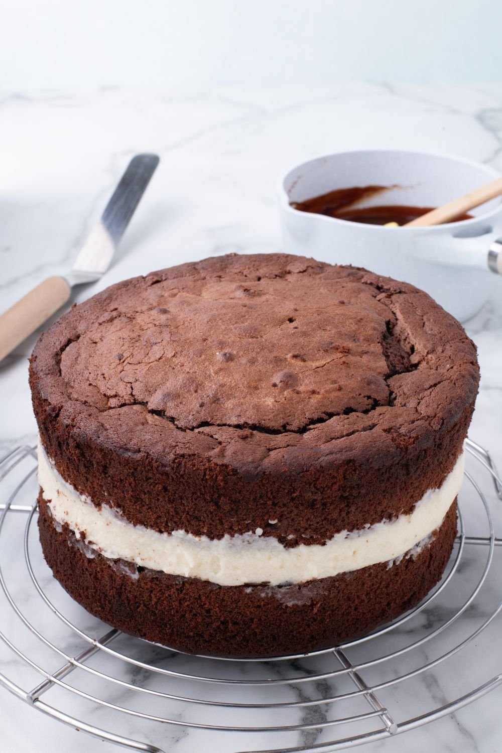 layered Ding Dong Cake that is unglazed sitting on tray, showing how to assemble the cake 