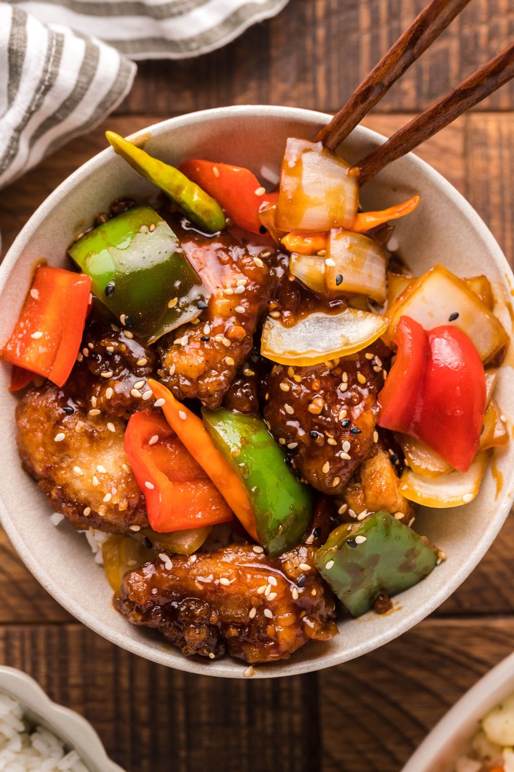 General tso chicken and veggies in a bowl topped with sesame seeds 