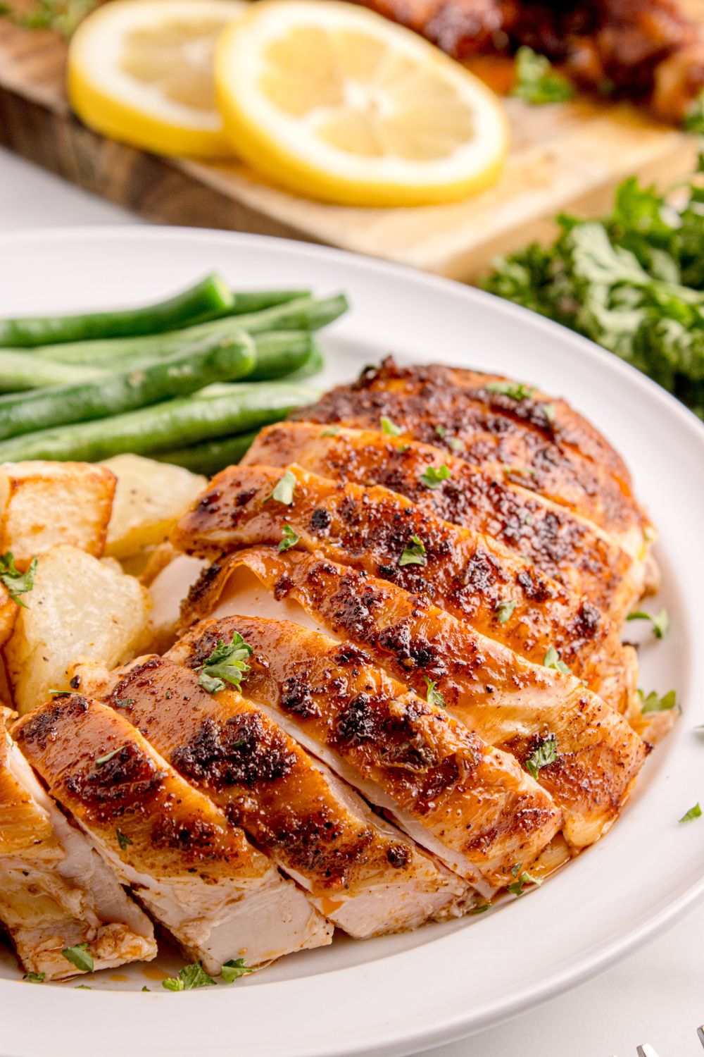 Smoked Whole Chicken sliced on plate with veggies on side of plate 