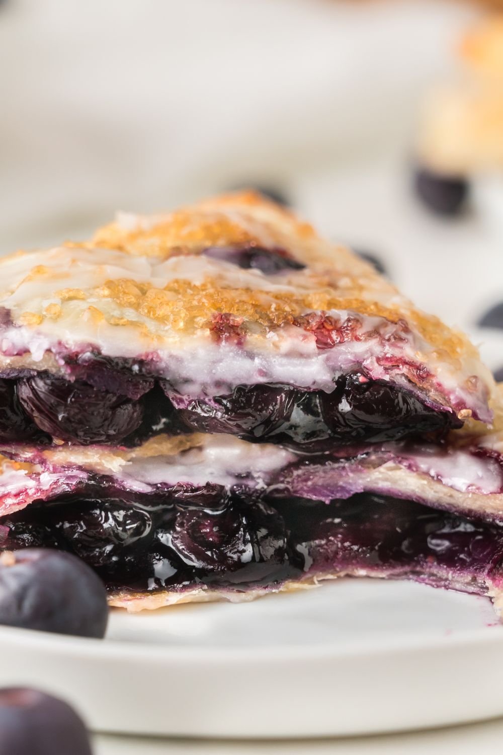 Blueberry Turnover cut in half and stacked on top of each other to showcase the blueberry filling inside the pastry 