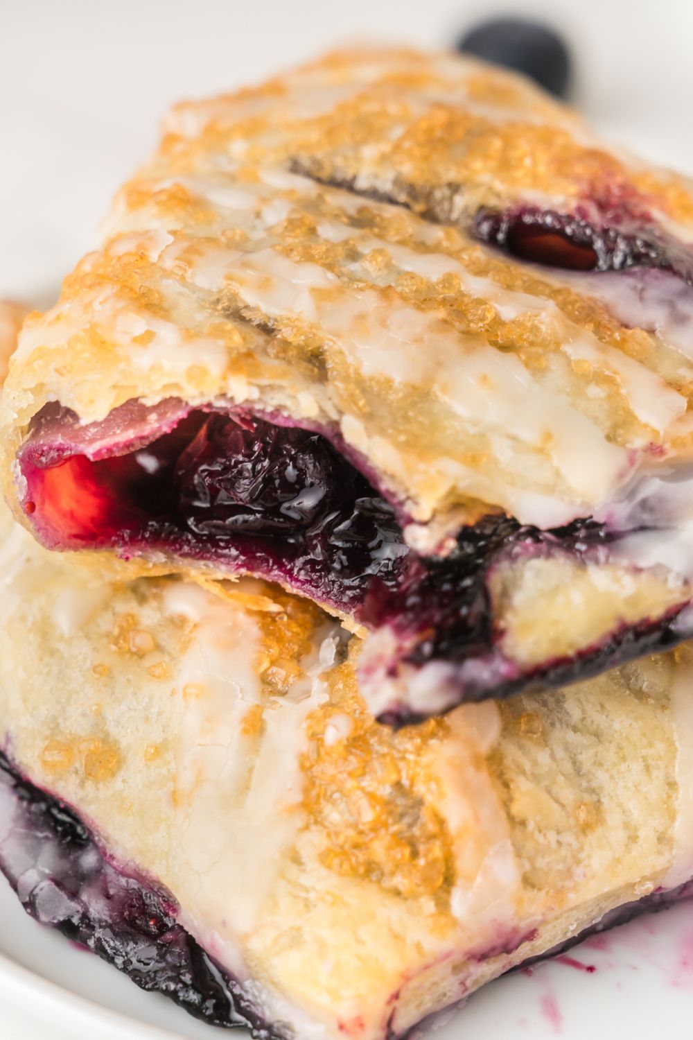 Blueberry Turnovers on a plate with one that has a bite taken out of it 