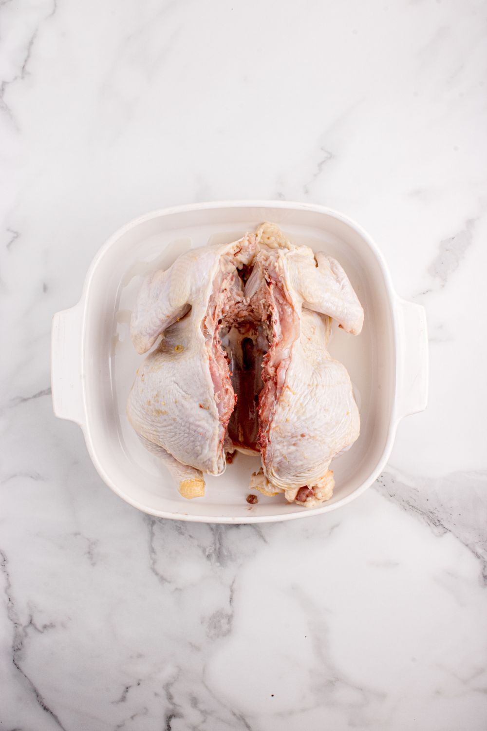 cut chicken in a casserole dish, raw