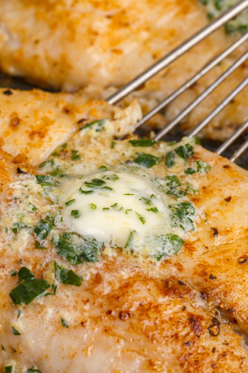 Pan Fried Tilapia with a skillet on side scooping it up 