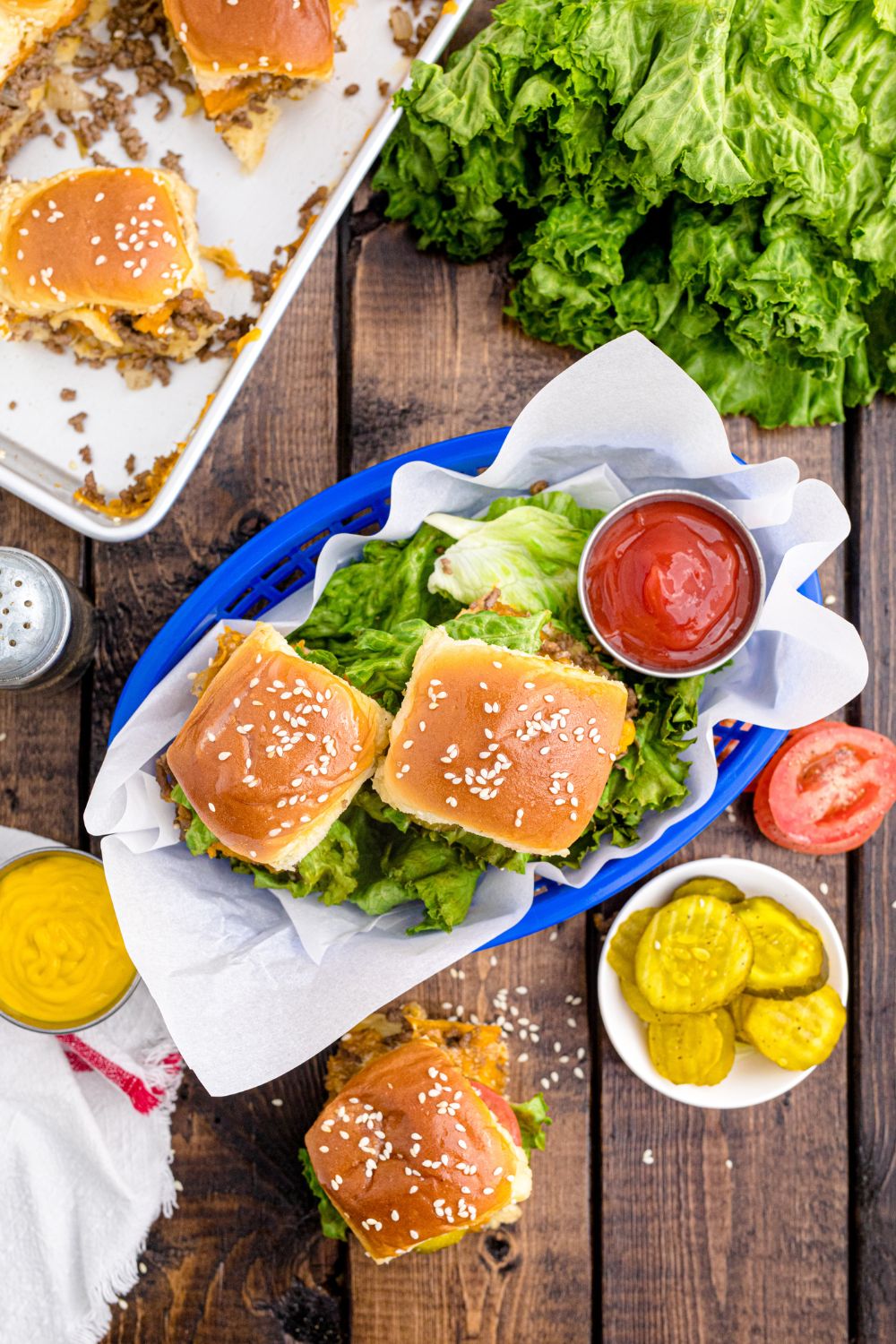 Classic Cheeseburger Sliders in a basket with lettuce and ketchup in a bowl 