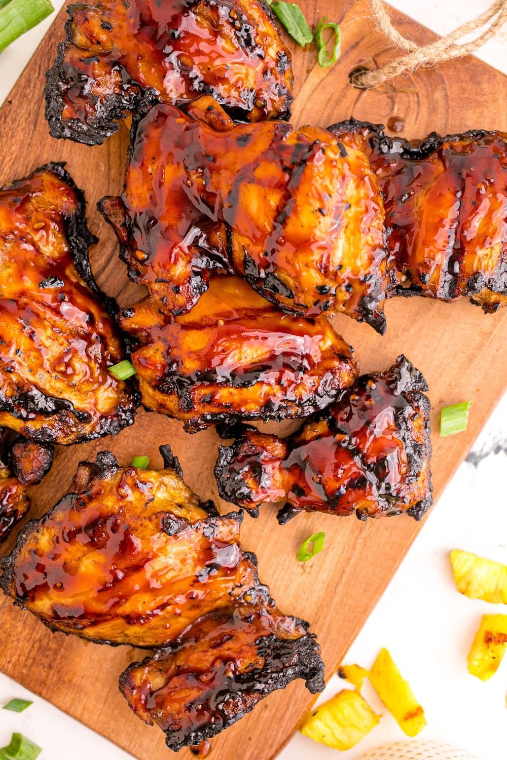 Huli Huli Chicken that has been grilled placed on a wooden board garnished